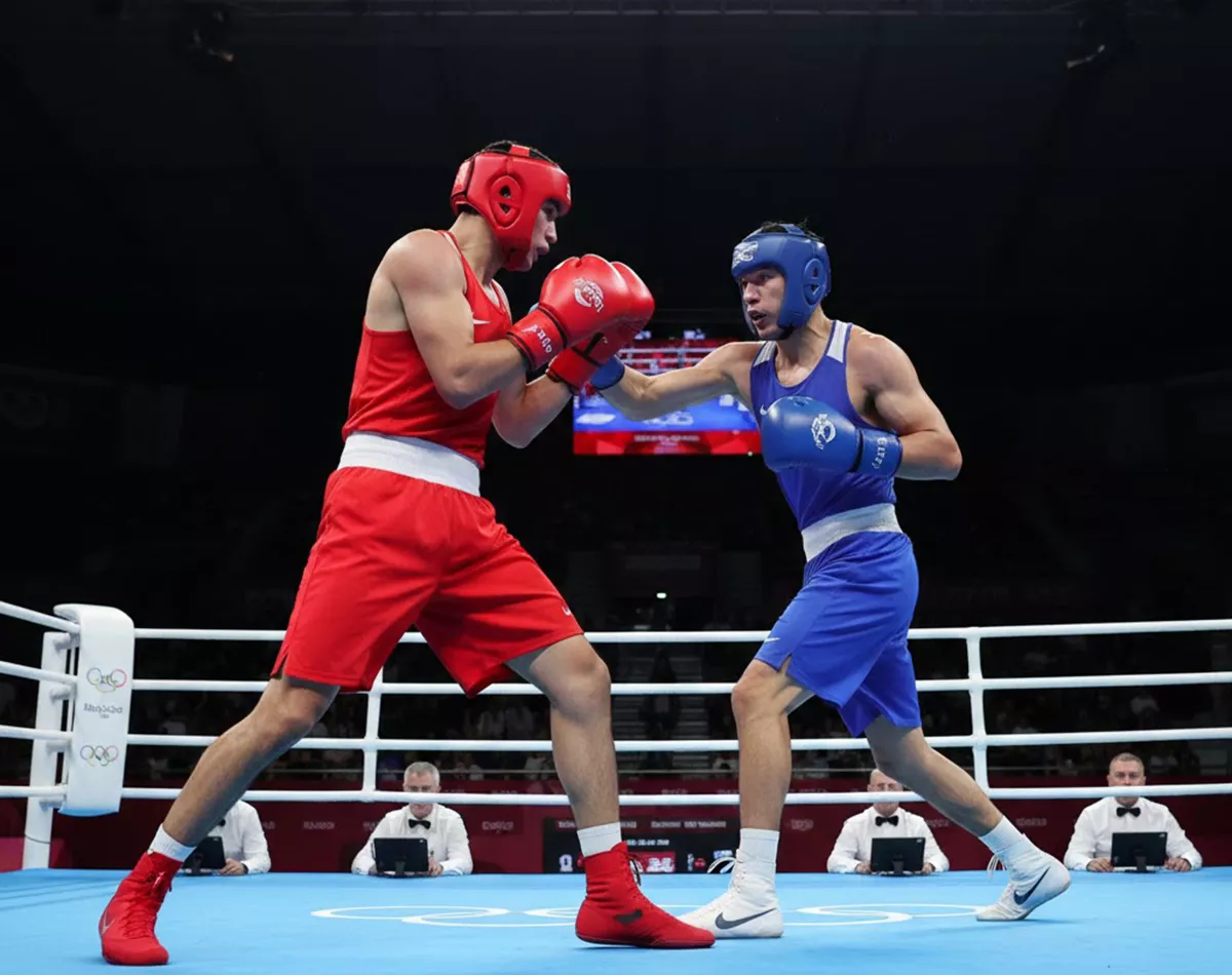 Boxeador amateur con casco protector y camiseta compitiendo en torneo olímpico